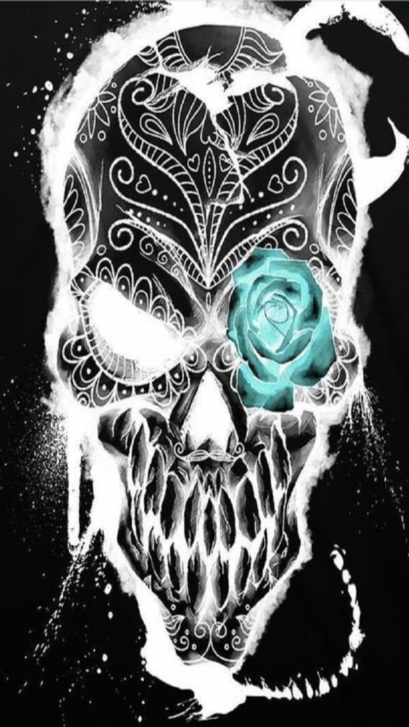White ornate skull with a glowing blue rose in the left eye socket against a dark black background with speckles.