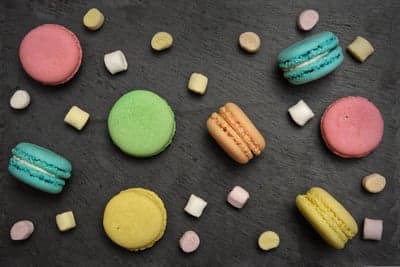 Colorful Macarons and Marshmallows on Dark Slate Background