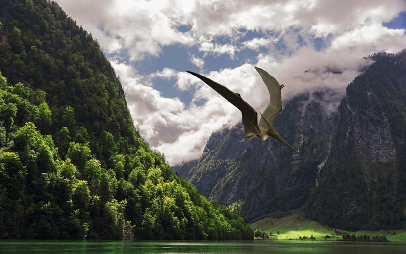 Pterodactyl with wide leathery wings glides above a turquoise mountain lake surrounded by dense evergreen forests.