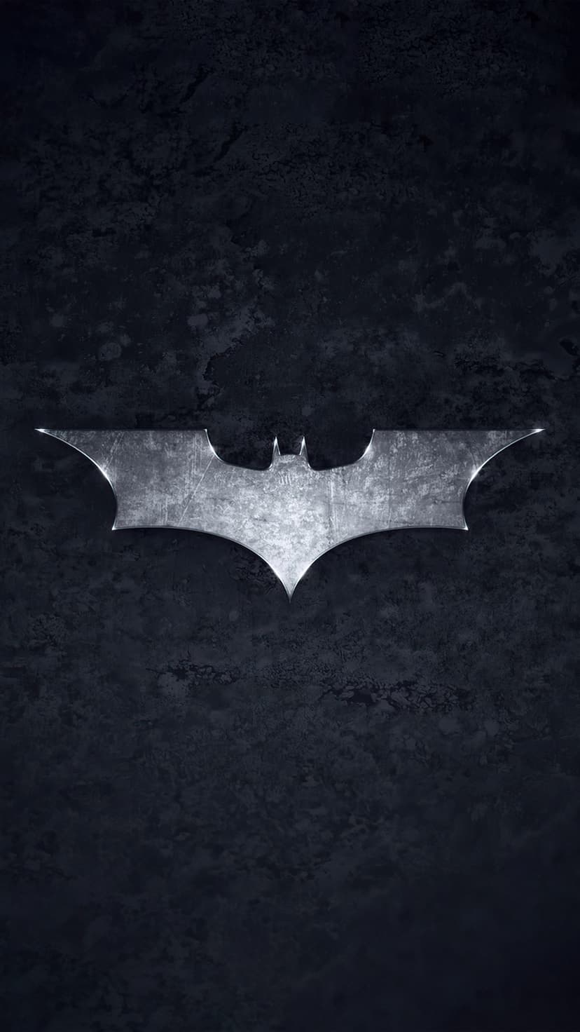 Silver Batman logo with scratches on a dark grey slate background featuring subtle edge highlights.