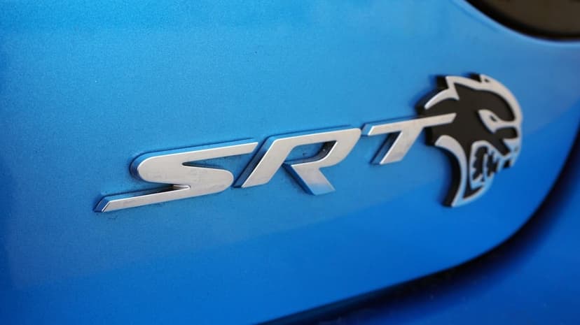 Chrome SRT letters and a black Hellcat logo badge on a bright metallic blue vehicle surface.