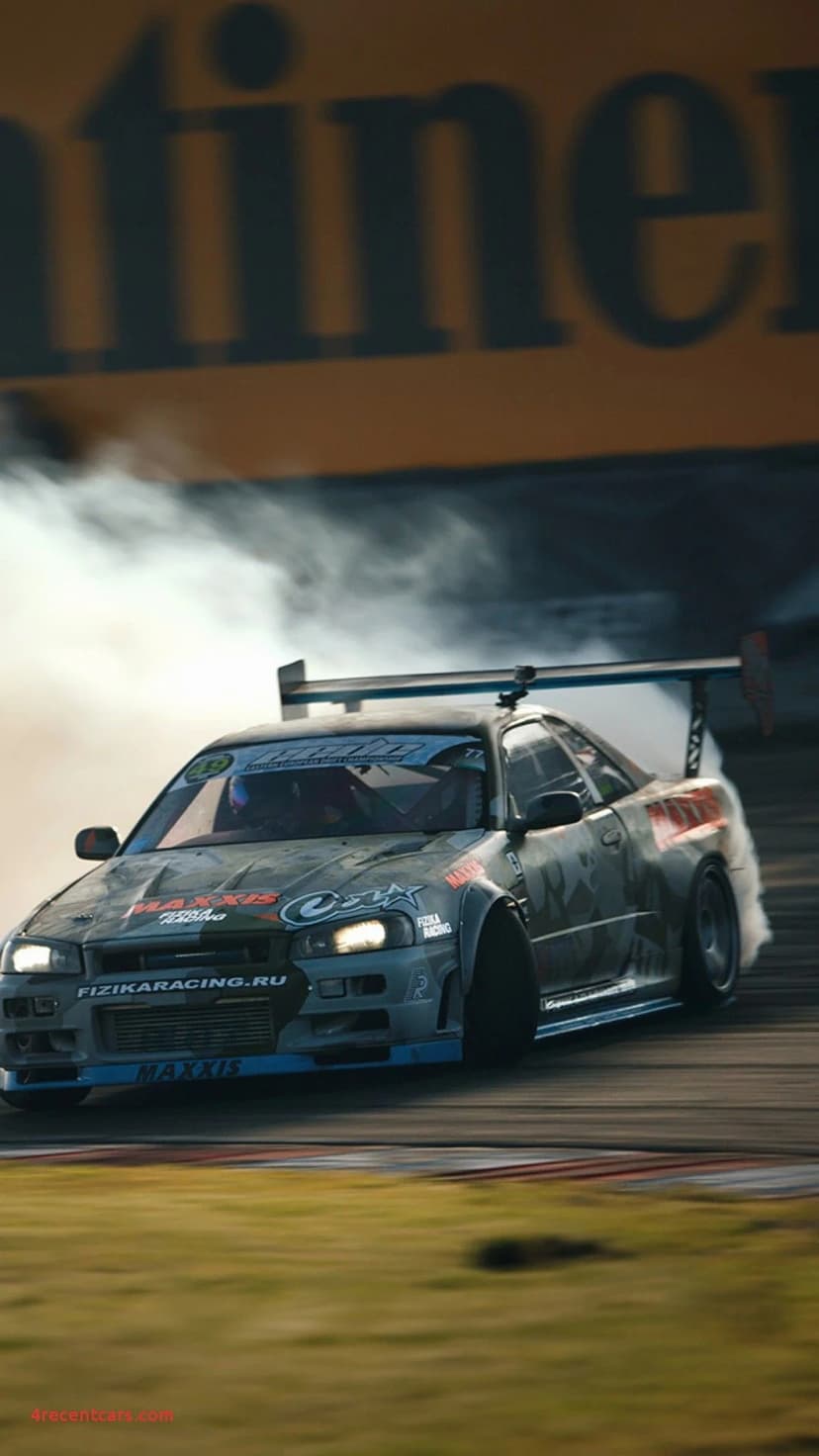 Nissan Skyline R34 GT-R drifting on a track with massive white tire smoke and custom Maxxis livery.