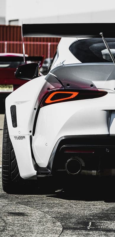 White Toyota Supra with large rear wing and exhaust