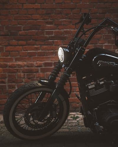 Black Harley Davidson Motorcycle Against Brick Wall