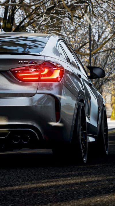 BMW X6 M rear view with glowing taillights in winter