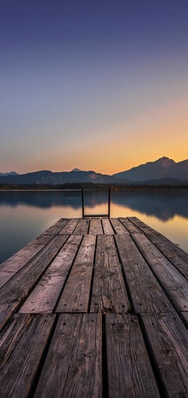 Pier's Embrace- Twilight Glow Over a Serene Lake and Mountains