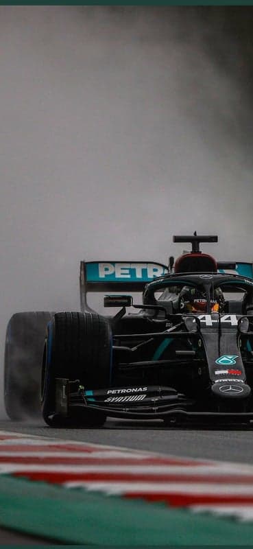 Formula 1 car racing in the rain, creating spray