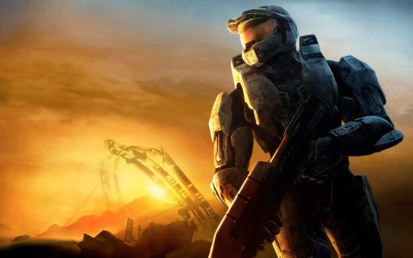 Spartan super soldier in green armor holding a rifle against a glowing orange sunset and metallic wreckage.