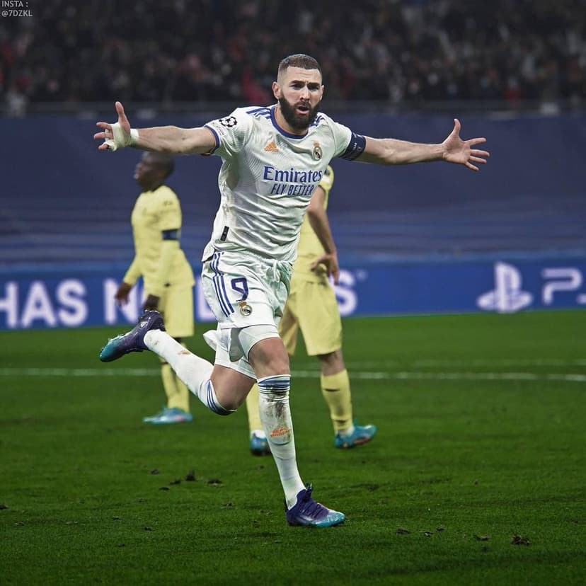 Karim Benzema in a white Real Madrid jersey celebrating a goal with stadium lights and yellow kits in the background