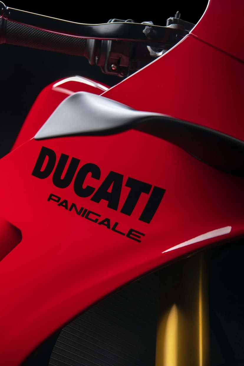 Red Ducati Panigale fairing with black branding and an aerodynamic winglet against a dark background.