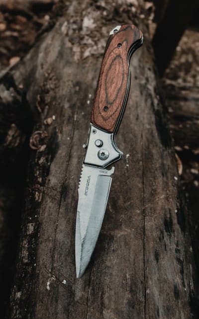 Tactical Folding Knife with Wooden Handle on Rustic Wood