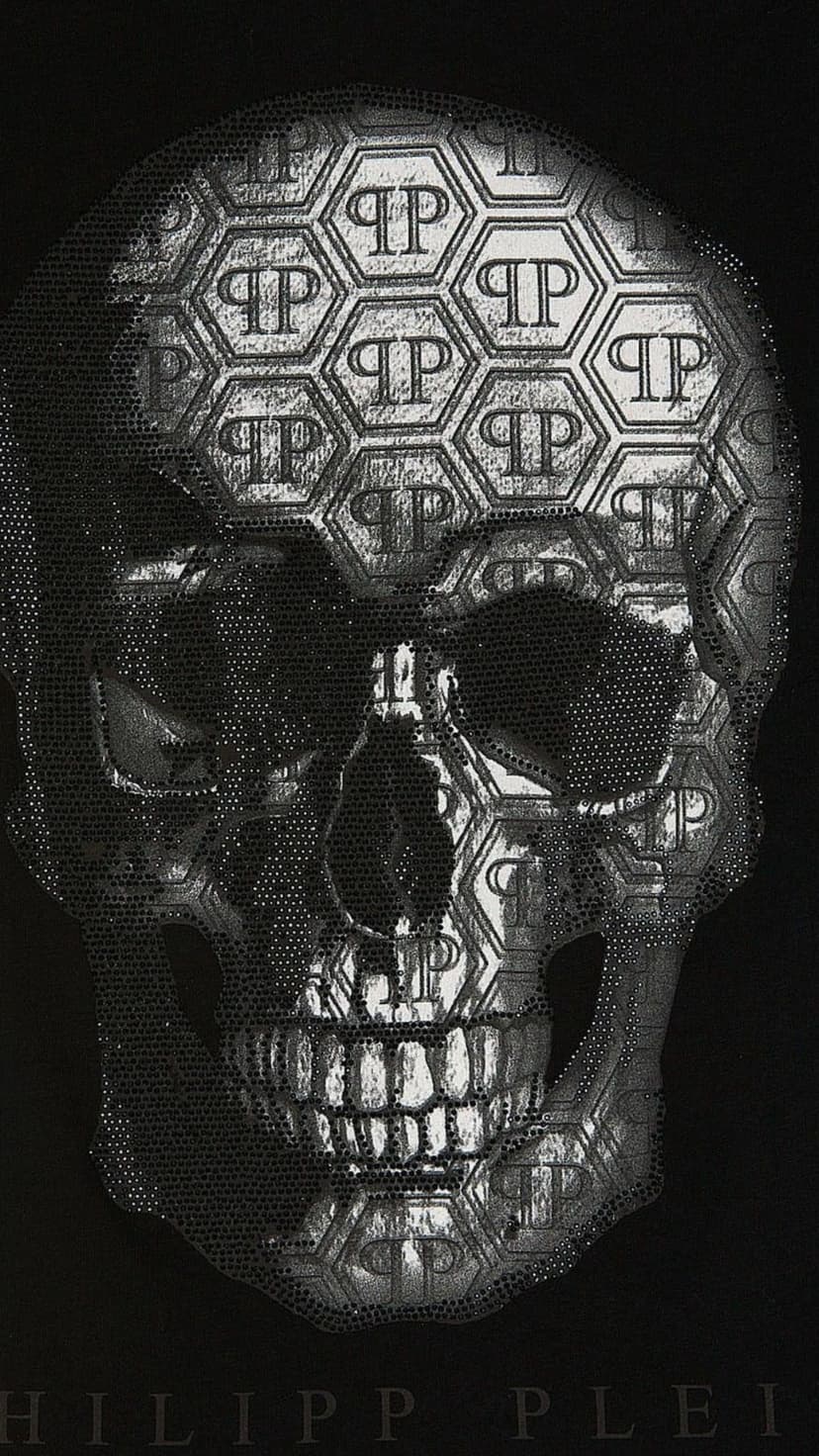 Silver metallic skull with hexagonal patterns and studded details on a black background for a luxury look.