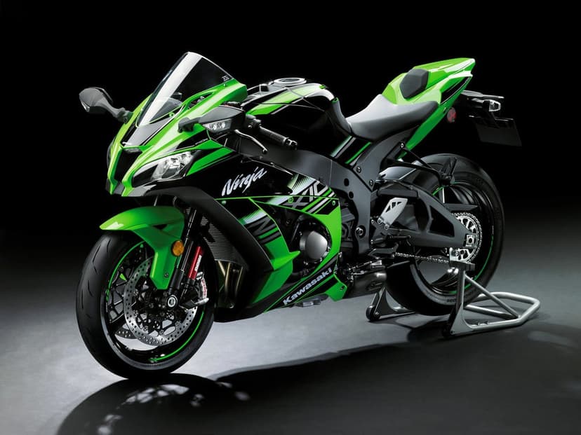 Green and black Kawasaki Ninja ZX-10R motorcycle on a paddock stand against a solid black studio background.