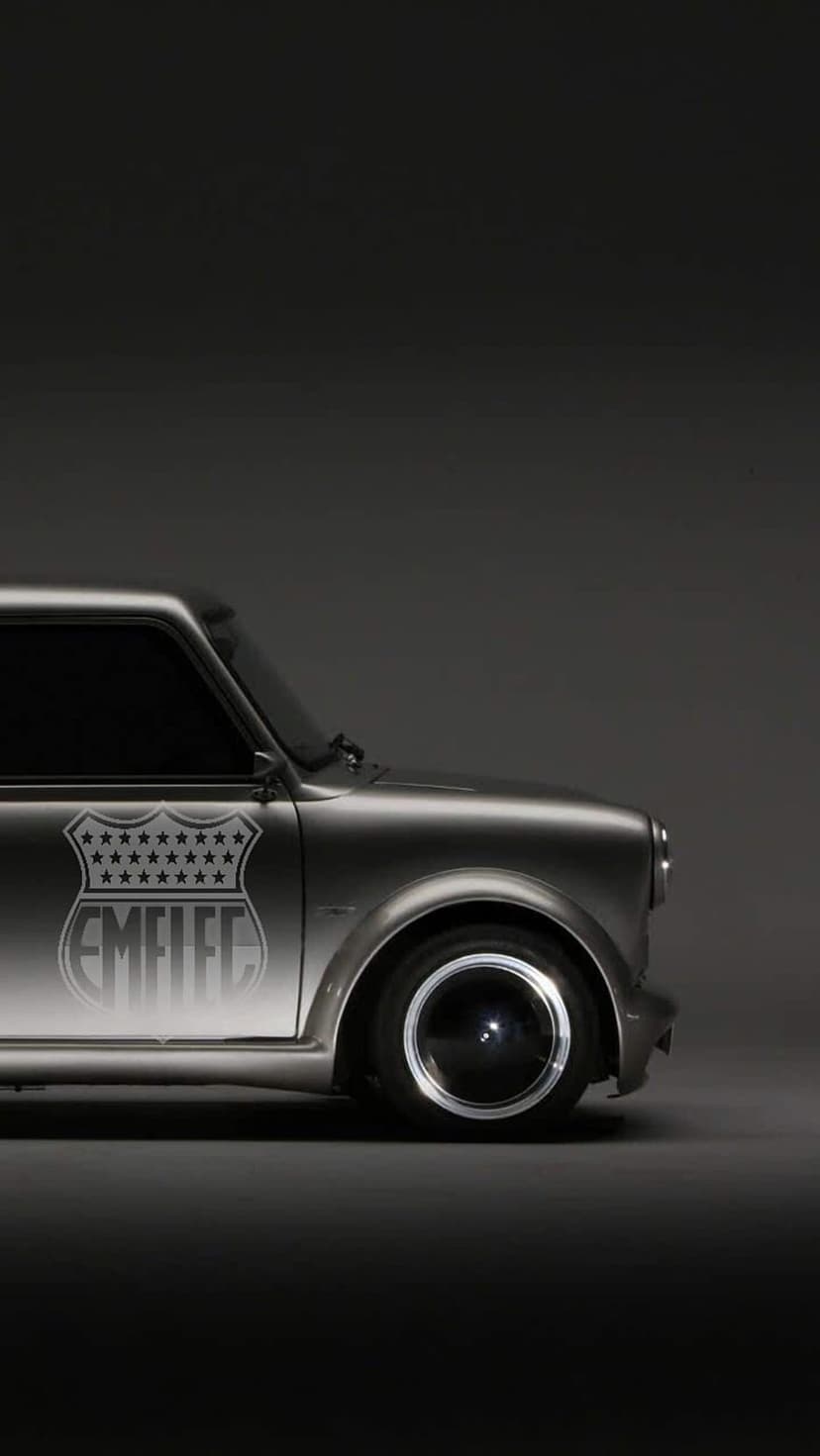 Silver Mini Cooper side profile featuring a star-covered EMFLEC badge and stylish multi-spoke custom wheels.