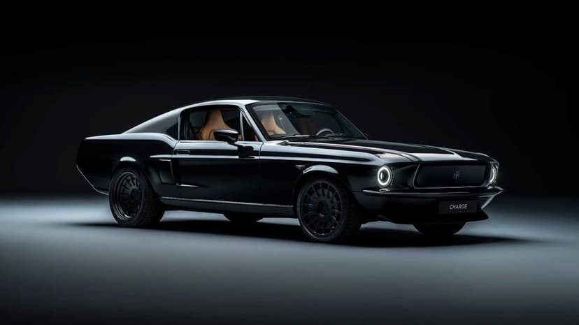 All-black electric classic muscle car with tan interior in a dark studio with dramatic lighting.