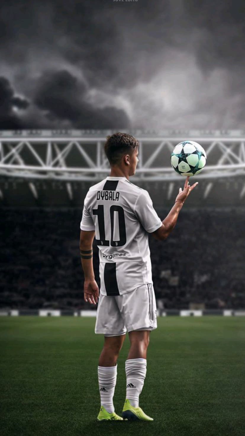 Paulo Dybala wearing his number 10 jersey spins a soccer ball on his finger under a stormy stadium sky.