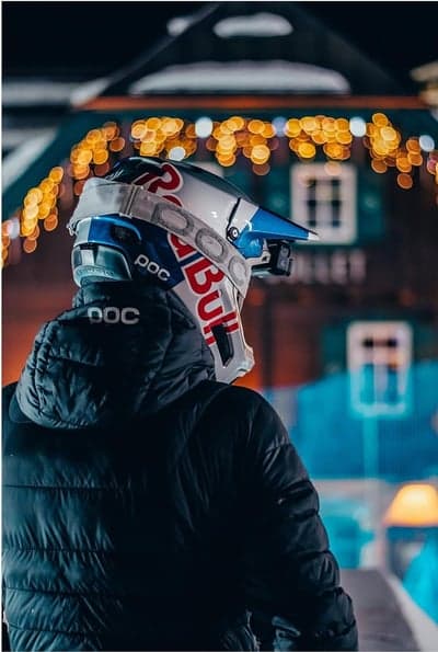 Athlete in Red Bull helmet at night with bokeh lights