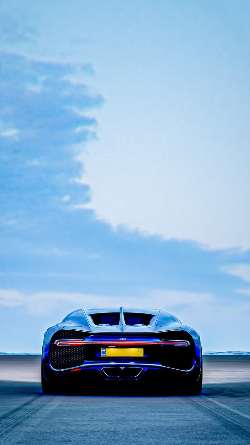 Bugatti Chiron rear view with glowing red taillights and yellow license plate speeding on a blurred road.