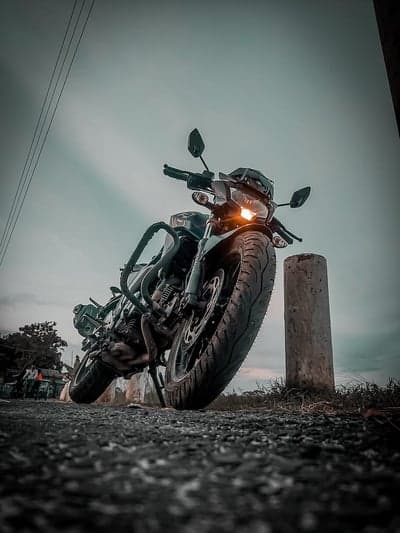 Motorcycle parked by roadside with dramatic sky
