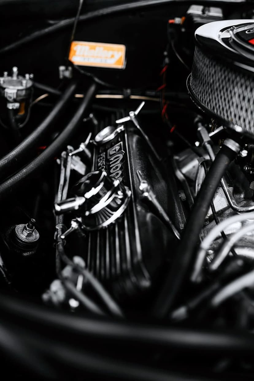 Chrome Mopar valve cover with a Holley label features polished metal textures and intricate engine components.