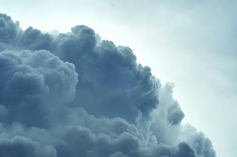 Dark turbulent storm clouds with swirling cauliflower textures and deep gray shadows in a vertical sky scene.