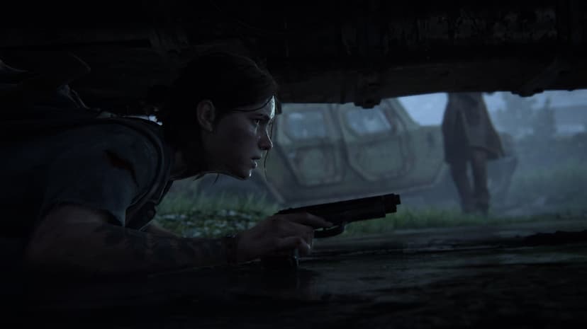 Ellie lies prone under a car holding a pistol, watching a blurred figure near a military vehicle in the rain.