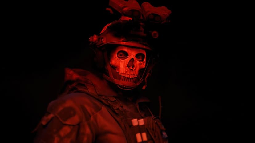 Ghost character wearing a weathered skull mask illuminated by a sharp red light in a dark tactical setting.
