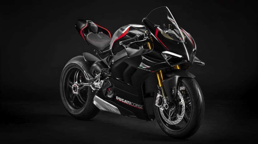 Matte black Ducati Panigale V4 SP sportbike with gold forks and red accents against a dark studio background.