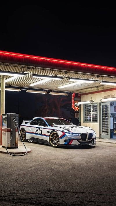 Vintage BMW M1 Racing at Neon Gas Station Phone Background