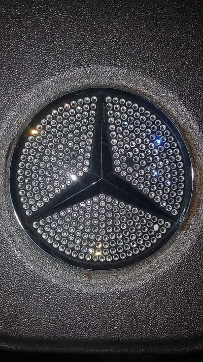 Sparkling Mercedes-Benz Logo on Textured Black Surface
