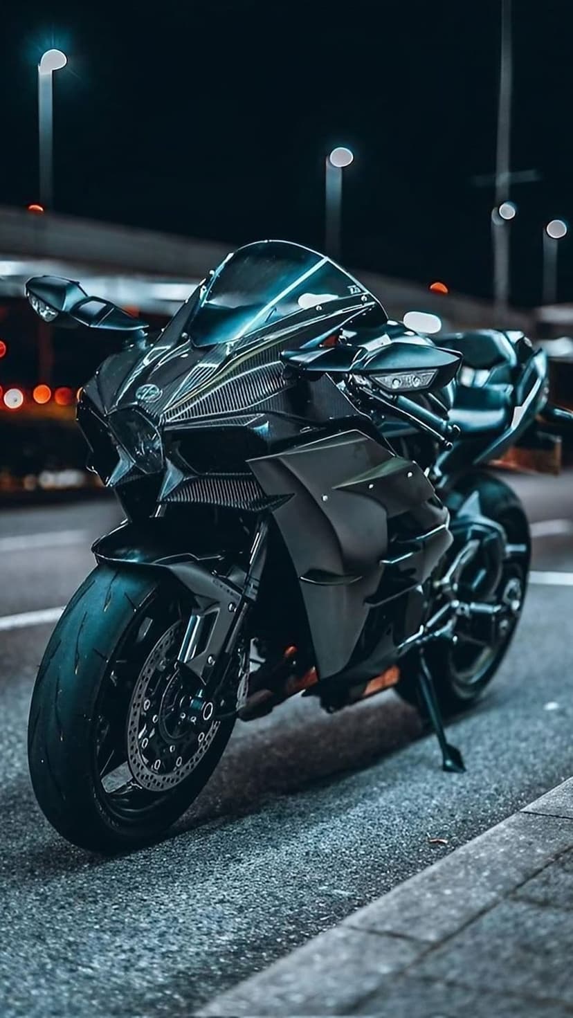 Black sport motorcycle parked on a wet city street at night with glowing bokeh lights reflecting on the pavement.