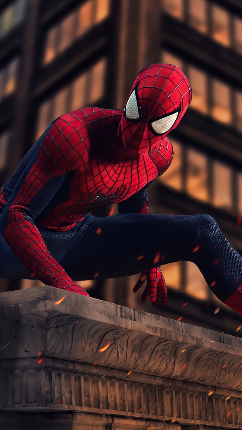 Spider-Man in a red and blue suit crouches on a stone ledge overlooking a bokeh city at night with floating embers.