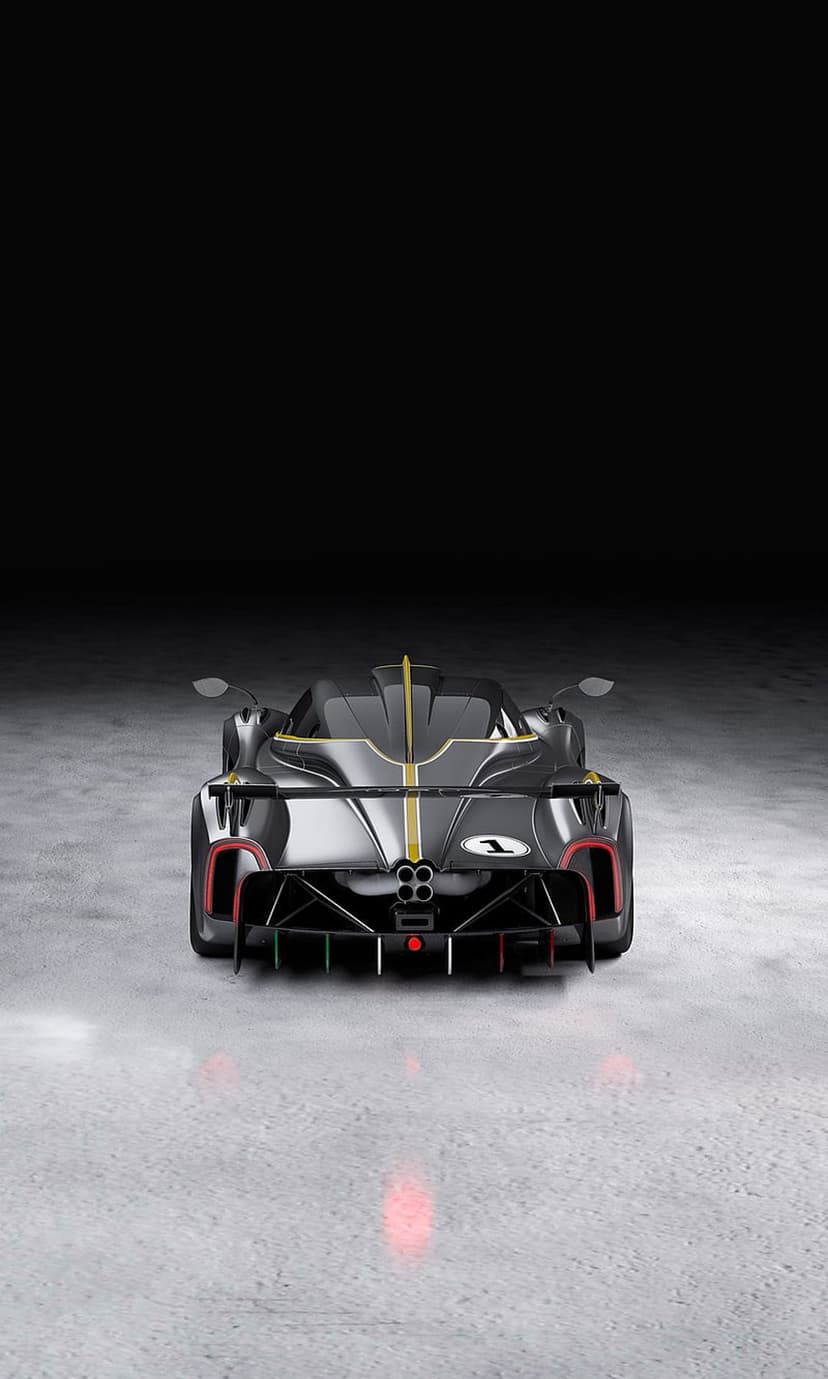 Black sports car rear view with gold racing stripes, quad exhausts, and glowing red taillights on a dark backdrop.