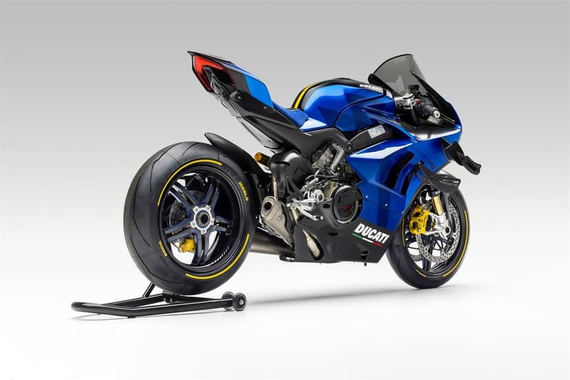 Blue and black Ducati Panigale V4 superbike on a rear stand against a white studio background with soft lighting.