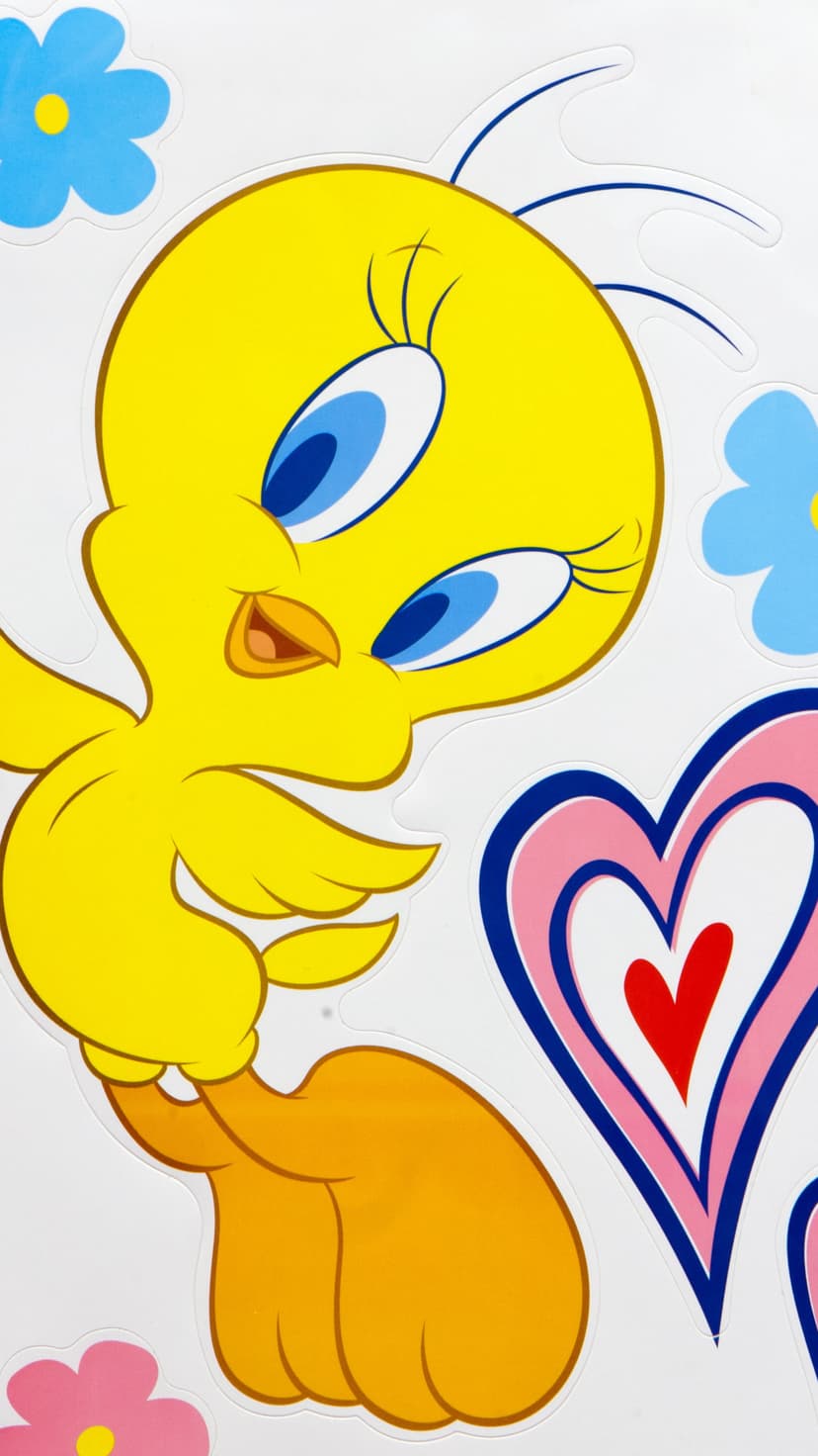 Tweety Bird with large blue eyes is surrounded by pink and blue flowers and a decorative heart on a white surface.