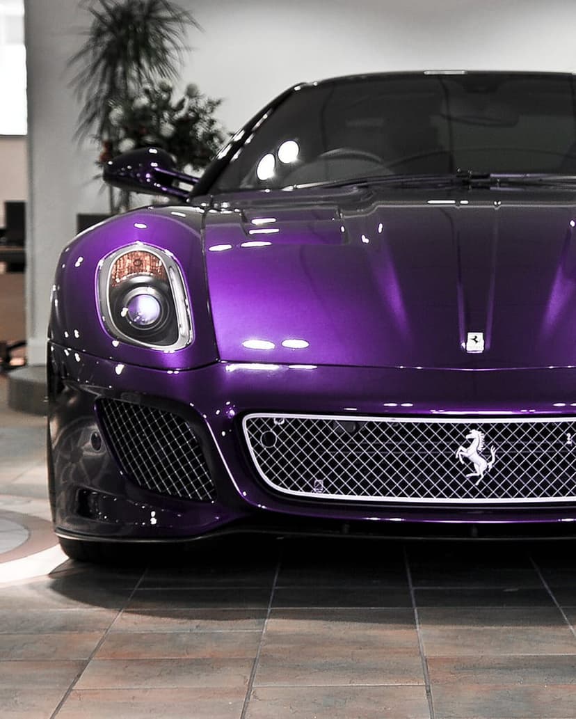 Purple Ferrari front grille and LED headlights in a showroom, showing the horse emblem on diamond mesh.