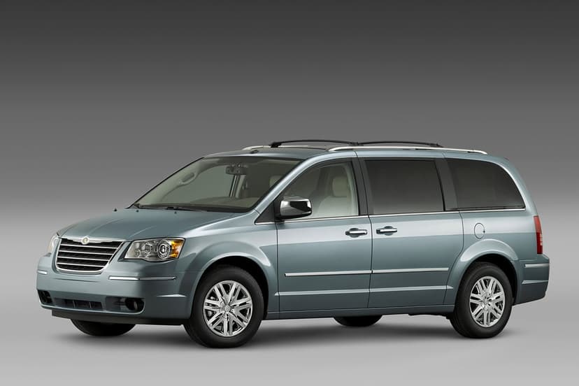Metallic silver Chrysler Town & Country minivan with chrome accents and alloy wheels on a gray background.