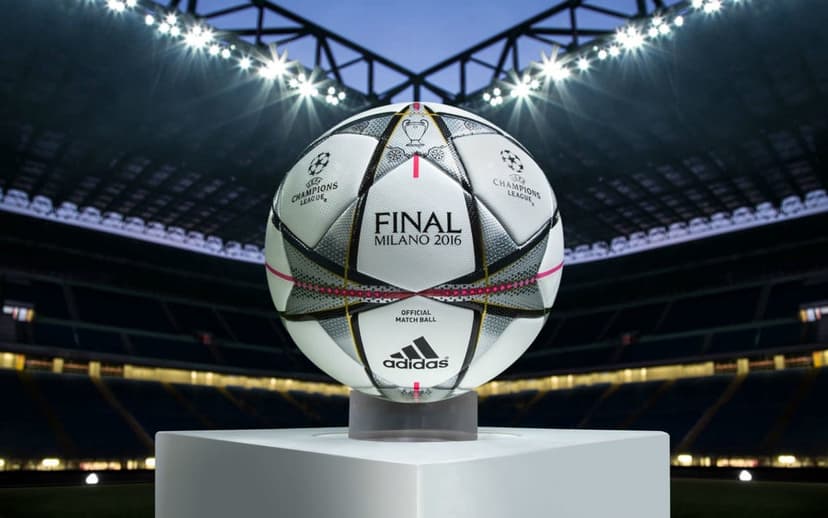 Adidas Finale Milano 2016 football with star-shaped panels and silver lettering on a green grass field.