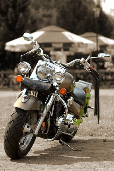 Vintage Motorcycle Parked Outdoors with Umbrellas in Background