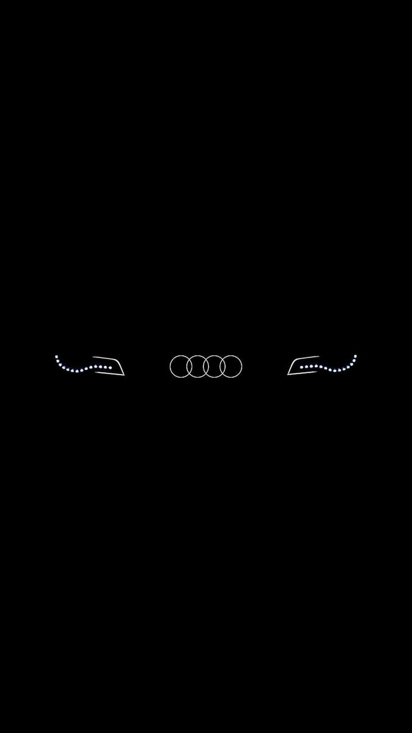 Audi rings centered between symmetrical white dotted outlines of car headlights on a solid black background.