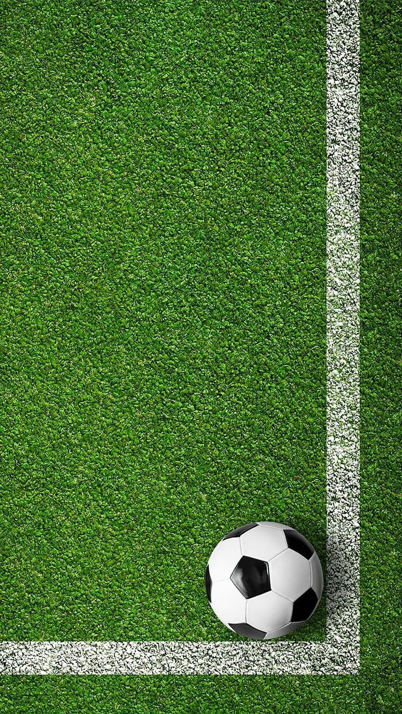 Black and white soccer ball rests on a bright green artificial turf field next to a solid white boundary line.