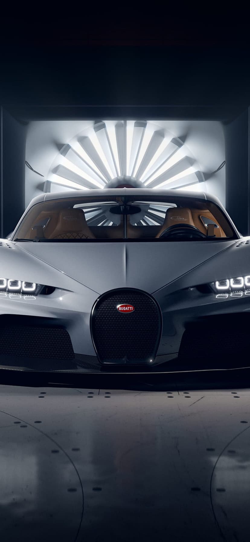 Silver Bugatti Chiron hypercar centered in a dark wind tunnel illuminated by concentric circles of white LED lights.