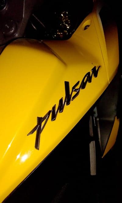 Chrome Pulsar Logo on Yellow Motorcycle Fairing Wallpaper