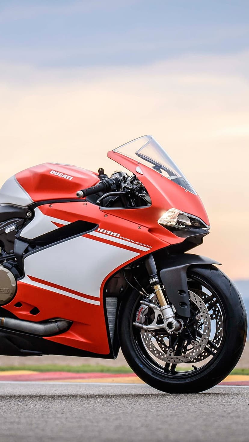 Red Ducati 1299 Superleggera sportbike with white fairing and high-performance disc brakes on a race track.