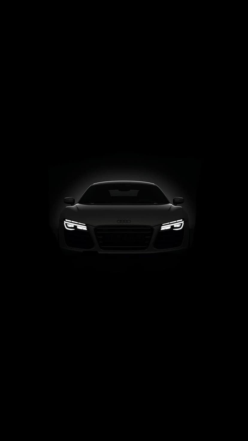 Audi R8 front view with illuminated LED headlights against a solid black background in vertical orientation.