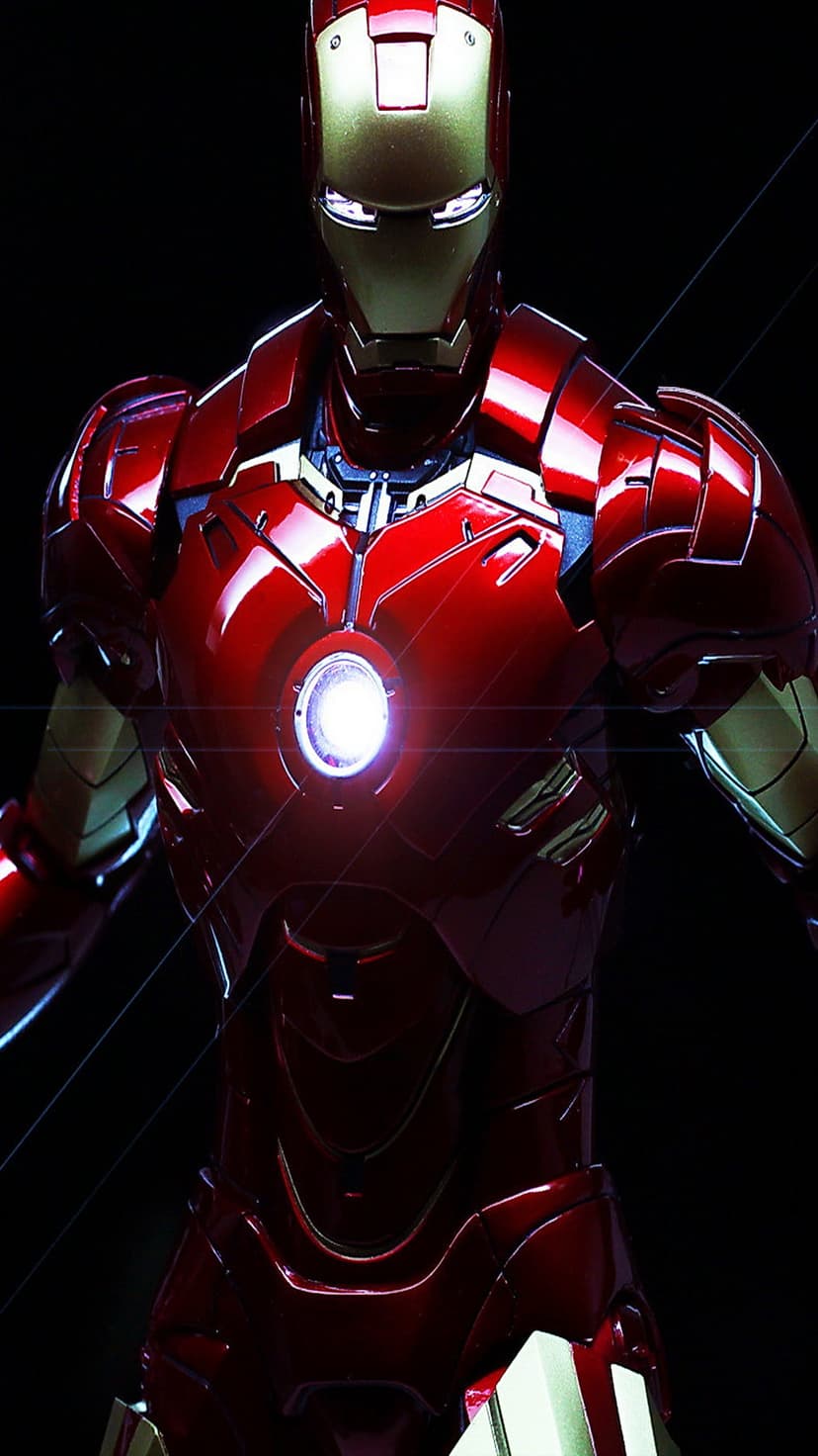 Iron Man's metallic red and gold chest plate centers on a glowing blue arc reactor with bright lens flare.