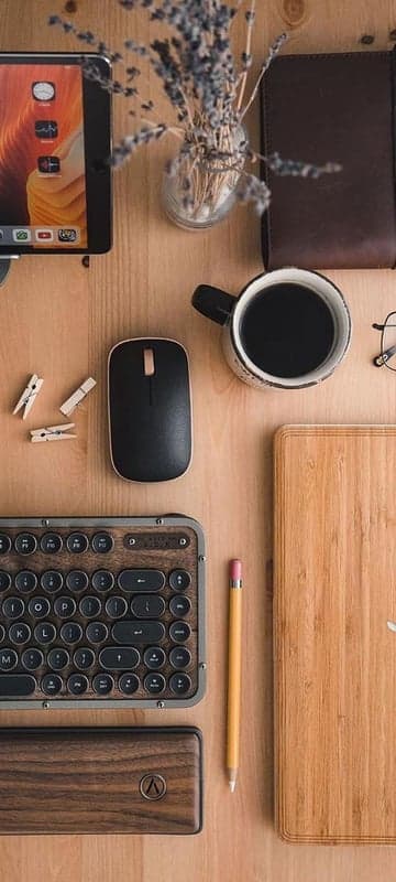 Cozy desk setup with coffee, keyboard, and tablet