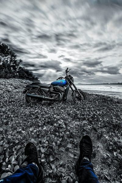 Motorcycle on a rocky beach under a cloudy sky
