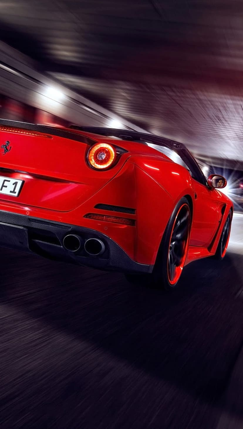 Red Ferrari convertible speeding through a dark tunnel with glowing red taillights and blurred concrete walls.