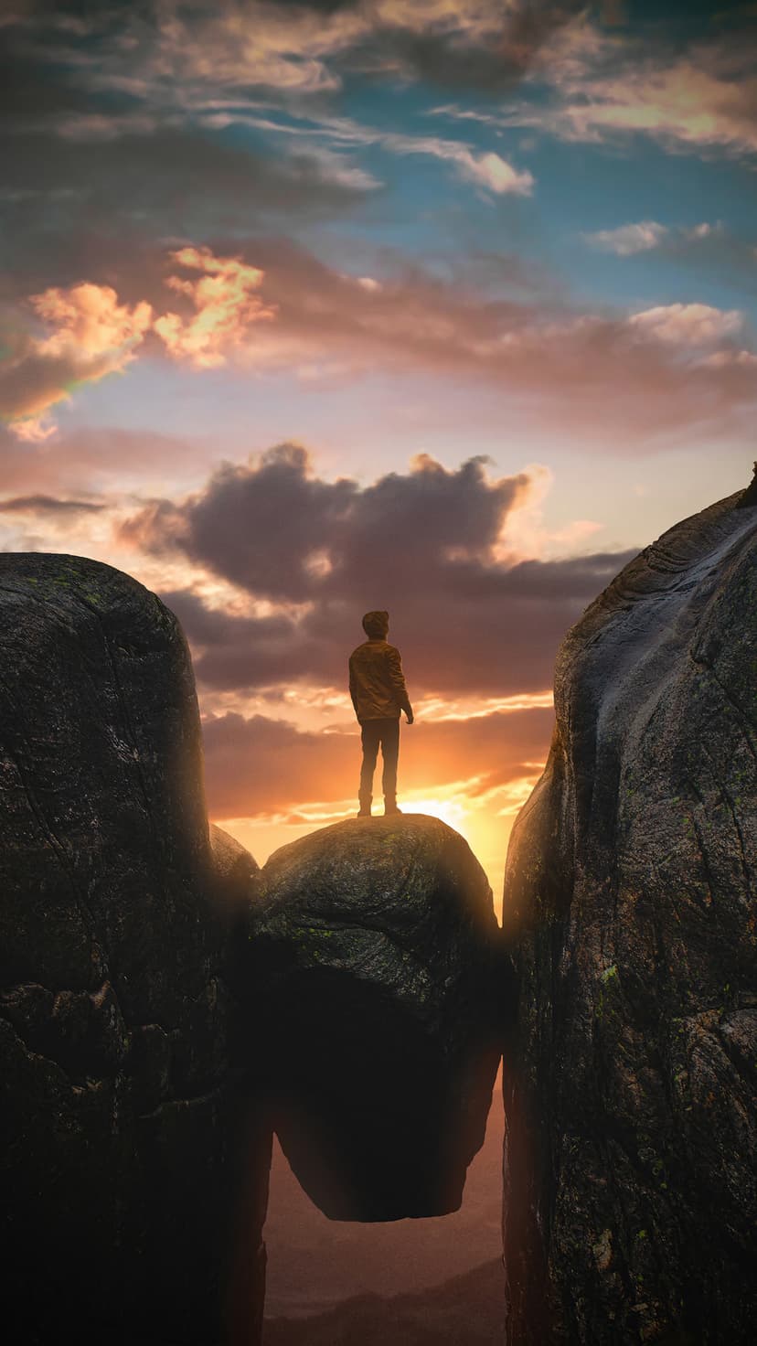 Man sitting on a car roof gazing at a vast wheat field under a glowing orange and blue twilight horizon.